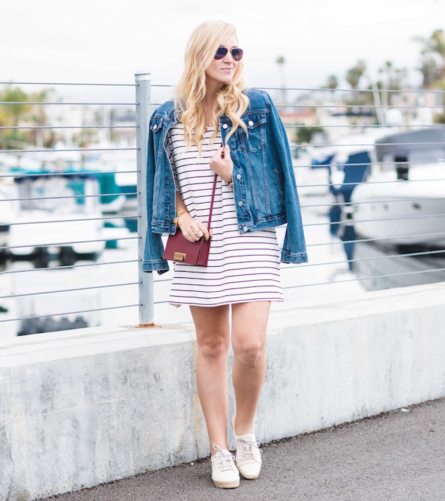 Orange County fashion blogger Nikki Prendergast of My Style Diaries wears a classic striped dress, denim jacket, and sneakers.