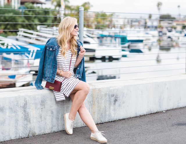 Orange County fashion blogger Nikki Prendergast of My Style Diaries wears a classic striped dress, denim jacket, and sneakers.