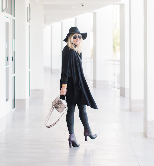 Fashion blogger Nikki Prendergast of My Style Diaries in Spanx leggings, cabi turtleneck and booties, and a Henri Bendel handbag.